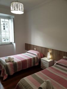 圣地亚哥－德孔波斯特拉Pensión Hedrass的一间卧室设有两张床和窗户。