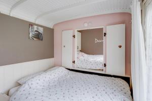 KuinrePipowagens 'Ot' en 'Sien'的一间小卧室,配有一张床和镜子