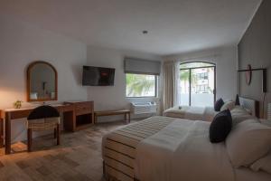 马萨特兰Gaviana Resort的一间卧室配有一张床、一张书桌和一面镜子