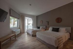 马萨特兰Gaviana Resort的酒店客房,设有两张床和一张沙发