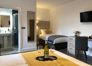 巴利米纳McNaughton Guestrooms的酒店客房带一张床和两杯葡萄酒