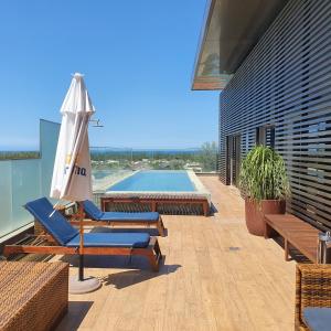 里约热内卢Vogue Square Fashion Hotel by Lenny Niemeyer的一个带椅子和遮阳伞的庭院和一个游泳池