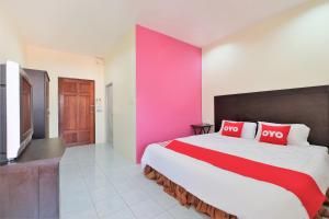 高兰OYO 609 Lanta Dream House Apartment的一间卧室设有一张大床和粉红色的墙壁