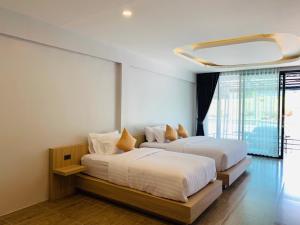 Ban Wang KhonBelong Boutique Luxury Hotel的白色墙壁客房的两张床