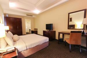 巴淡岛中心和谐会议酒店及服务公寓的配有一张床和一张书桌的酒店客房