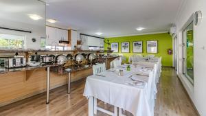 德班银橡树精品酒店的一间设有白色桌子和厨房的餐厅