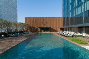 曼谷Carlton Hotel Bangkok Sukhumvit的一座建筑物中央的游泳池