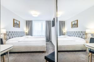 比亚韦斯托克波德拉谢酒店的酒店客房,设有两张床和镜子