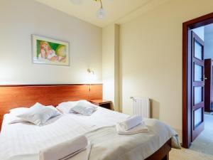 什切尔克斯卡里特温泉及健康酒店的卧室配有一张白色大床和两条毛巾