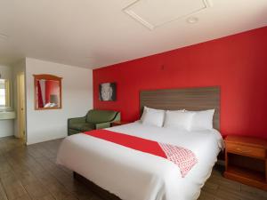 圣安东尼奥OYO Hotel San Antonio near AT&T Center的酒店客房设有一张大床和红色的墙壁。