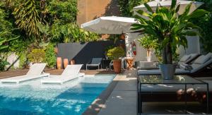 里约热内卢卡萨格兰诺酒店的一个带白色椅子、遮阳伞和桌子的游泳池