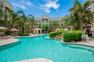 格伦代尔Holiday Inn Express & Suites Phoenix Glendale Dist, an IHG Hotel的棕榈树度假村的游泳池