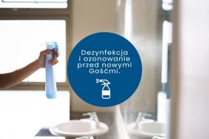 华沙ClickTheFlat Hoża Street Apart Rooms的把牙刷放在浴室镜子前的人