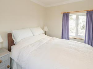 拉尔Jasmine Cottage的卧室配有白色的床和窗户。