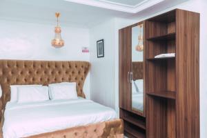 莱基247 Luxury Hotel的一间卧室配有一张床和一个木制橱柜