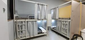 圣地亚哥－德孔波斯特拉嘉居旅游旅舍的带3张双层床和窗帘的房间