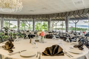 亚历山德里亚贝邦尼城堡码头度假酒店的用餐室配有白色桌子和黑色椅子