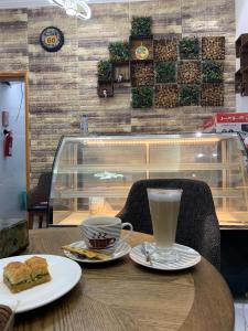 ḨilfAL JOOD HOTEL APARTMENT的一张桌子,上面放着一杯咖啡和三明治