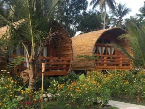 庞岸达兰Lagoona Beach Bungalows - Eco Stay的花园中带茅草屋顶的房子