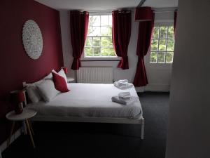 海斯红狮酒店的一间卧室设有一张带红色墙壁和窗户的床。