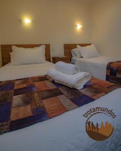 纳塔列斯港Trotamundos的酒店客房,配有两张床,床上有被子