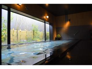 富士市露樱酒店 新富士站南(Hotel Route Inn Shinfuji Ekiminami)的大型游泳池设有大窗户