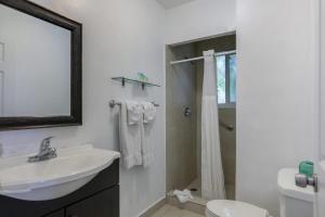 好莱坞Hollywood Broadwalk Oceanside Hotel的白色的浴室设有水槽和淋浴。