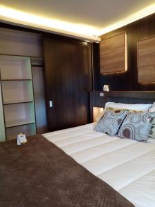CabreroHotel Mont Suite-Mte. Aguila的一间卧室配有一张大床和木制床头板