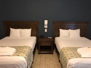 梅里达Hotel las Margaritas Merida的酒店客房,配有两张带白色床单的床
