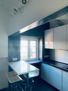 里斯本Restelo House Shared Appartment的厨房配有白色橱柜、桌子和窗户。