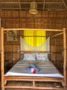 Looc布埃纳维斯塔天堂度假酒店的竹间的一个床位,有黄色窗帘