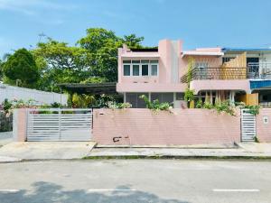 峇都丁宜Smell rose beach garden的粉红色的房子,设有大门和栅栏