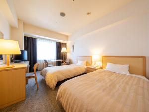 水户水戶总统大酒店(President Hotel Mito)的酒店客房设有两张床和电视。