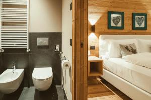 圣维托-迪卡多雷FIORI Dolomites Experience Hotel的一间带卫生间、水槽和床的浴室