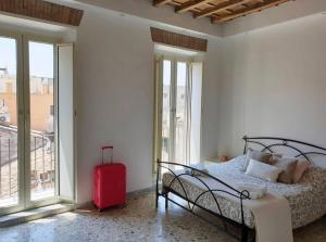 罗马Campo24roma Guesthouse的一间卧室配有一张床和一个红色的行李箱