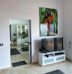 La Victoria de AcentejoLa Palmita的客厅配有电视和墙上的绘画