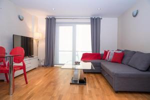 恩菲尔德Tranquil Apartment with Stunning Views的客厅配有灰色的沙发和红色的椅子