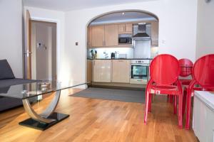 恩菲尔德Tranquil Apartment with Stunning Views的客厅配有玻璃桌和红色椅子