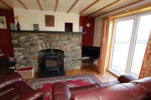 LybsterTaigh An Clachair的客厅设有石制壁炉和真皮沙发。