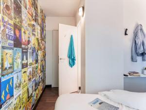 尚贝里hotelF1 Chambéry Nord Rénové的一间设有床铺和一堵带海报的墙壁的客房