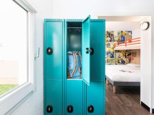 尚贝里hotelF1 Chambéry Nord Rénové的一张蓝色的橱柜,位于一个配有床的房间
