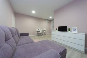 基辅Чудесная 2 комнатная квартира люкс уровня Теремки的客厅配有紫色沙发和电视
