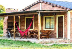 圣哈维尔La Maína Cabañas的砖屋,设有野餐桌和红色吊床