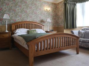 阿尼克Greycroft B&B的一间卧室配有一张木床和一张沙发