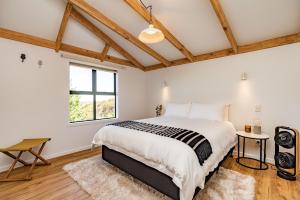 芒阿法埃Tui & Nikau Cabins的一间卧室设有一张大床和一个窗户。