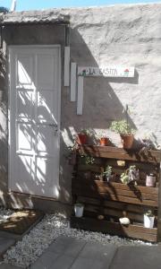 内乌肯La Casita的一座建筑旁的白色门,上面有盆栽植物