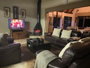 贝拉贝拉Twiga Lodge Mabalingwe的客厅配有真皮沙发和电视