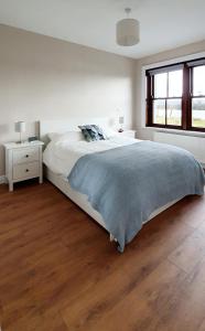 LanesboroughRiverside Marina Apartments的一间铺有木地板的白色卧室,配有一张床