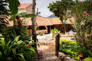 比尔卡班巴Hostal Jardín Escondido的房屋前设有带桌椅的花园