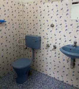 古鲁瓦尤尔Shiva Inn的浴室设有蓝色的卫生间和水槽。